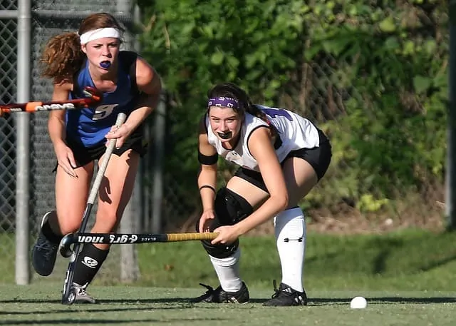 girls playing field hockey