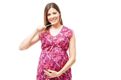 pregnant woman brushing teeth